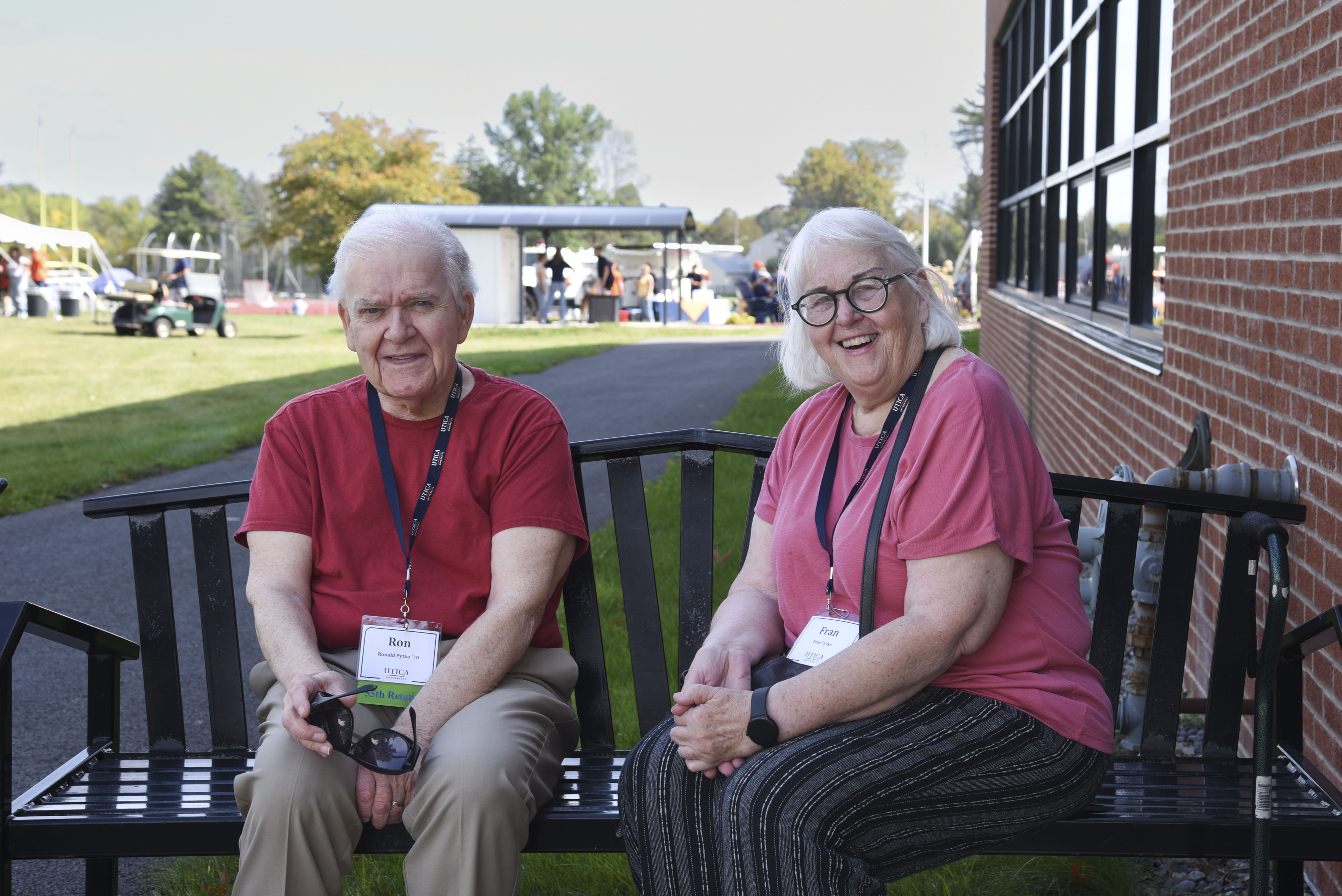 Ron ’70 and Fran Pytko sit on a bench on a sunny day during Homecoming 2025.